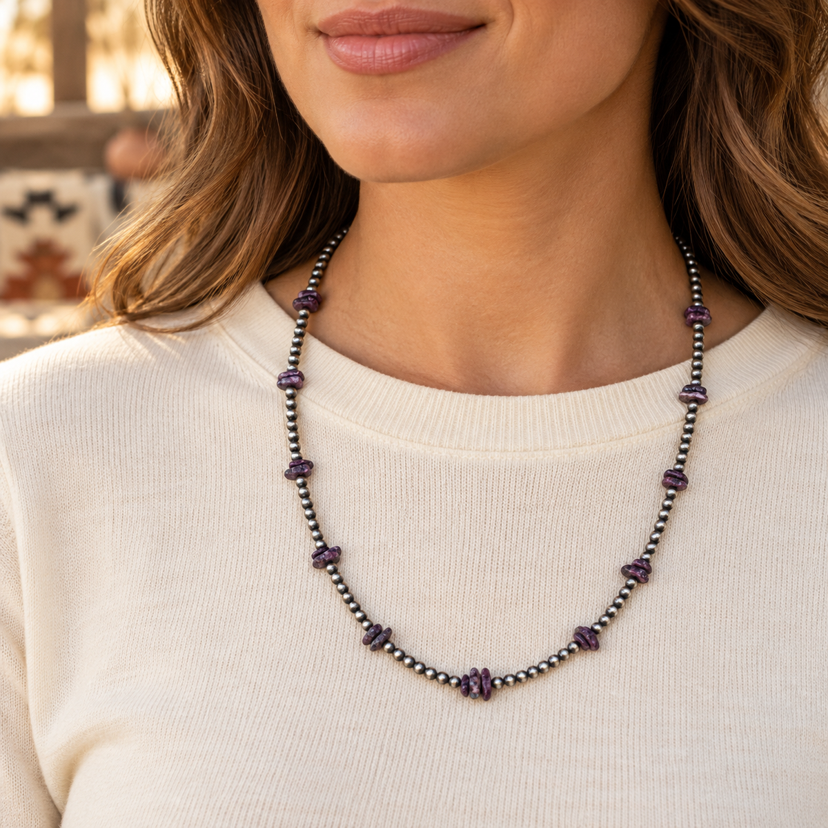 Purple spiny oyster and silver Desert Pearl necklace worn over a cream crew-neck top.