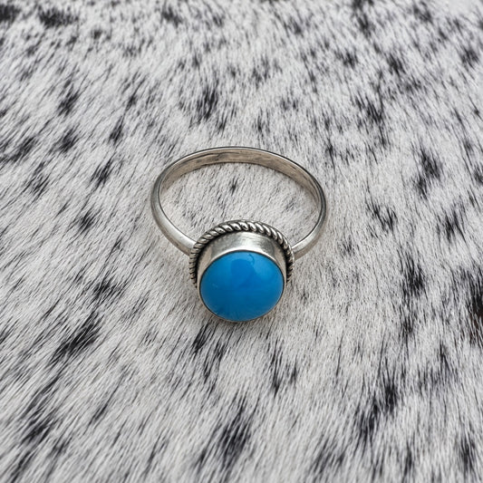 Turquoise Classic Oval Ring on gray-and-white cowhide