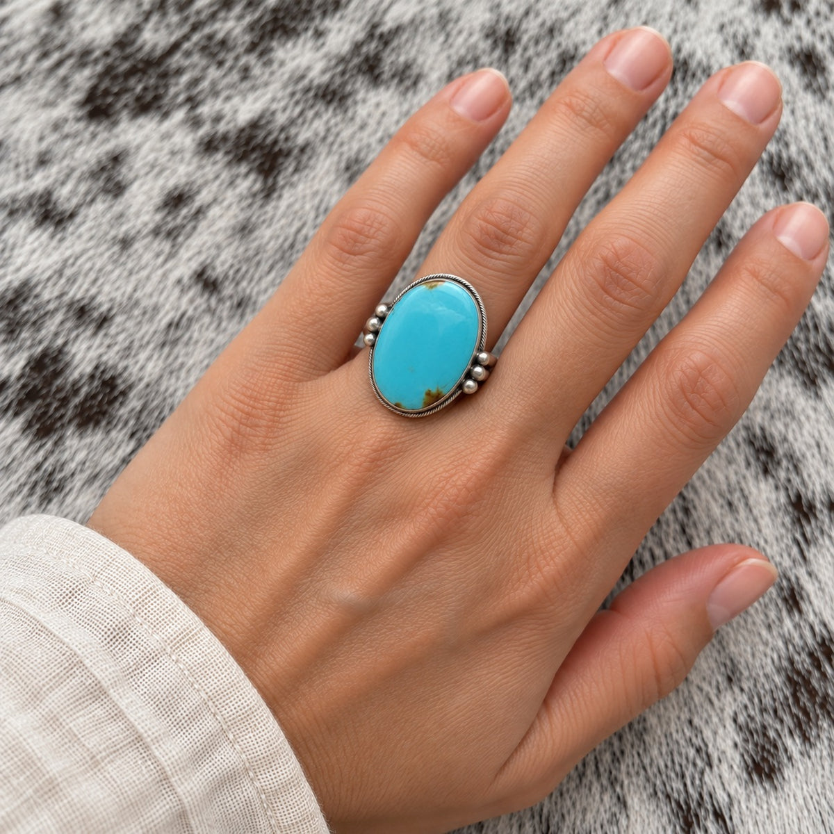Turquoise Mine 8 Oval Ring worn around a finger; approximate scale