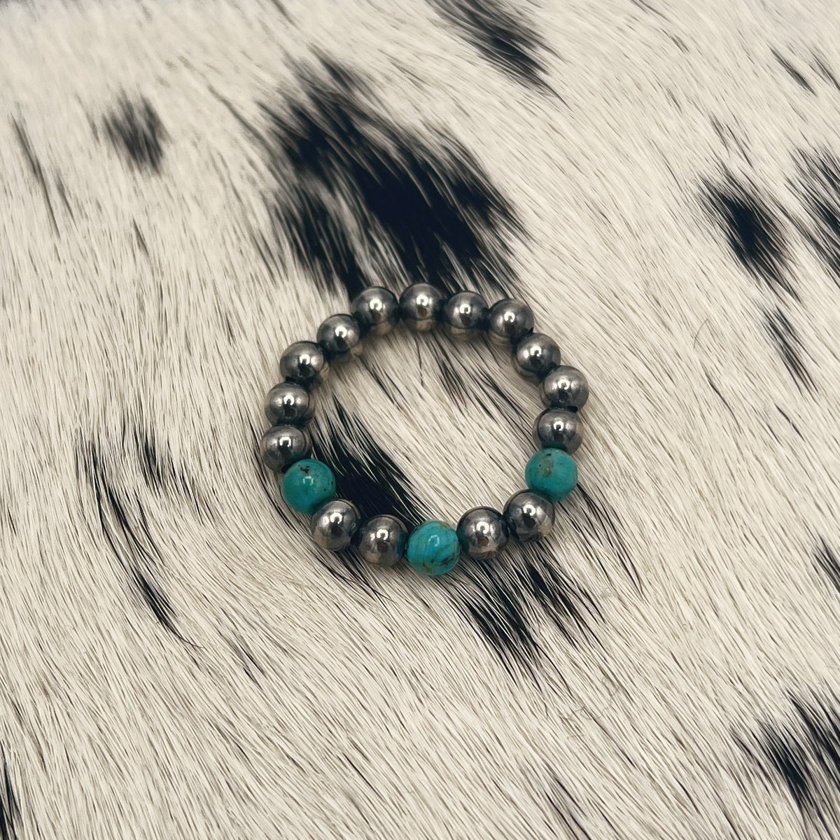 Another view of the blue turquoise and silver bead stretch ring on cowhide