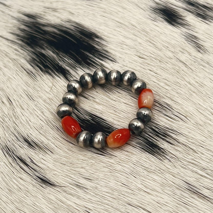Spiny oyster Desert Pearl stretch ring with 4mm sterling silver beads on a cowhide mat