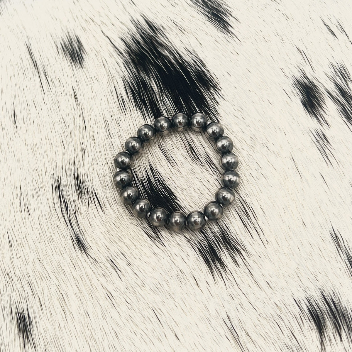 Another view of the all silver Desert Pearl bead stretch ring on cowhide