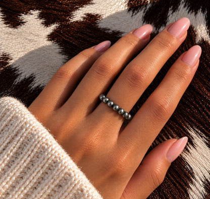All silver Desert Pearl stretch ring worn on a finger