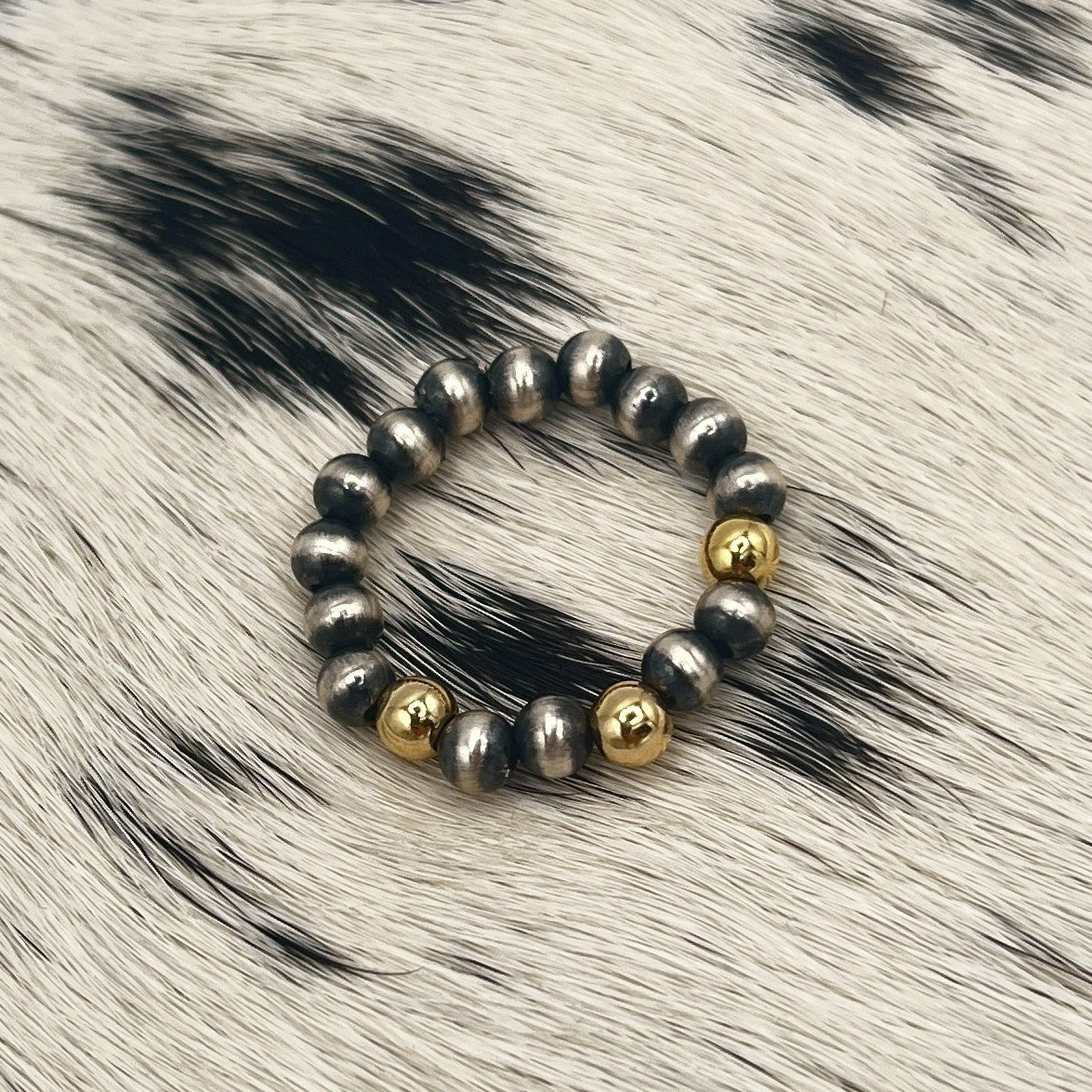 Desert Pearl stretch ring with 4mm sterling silver beads and three 12k gold filled beads on a cowhide mat