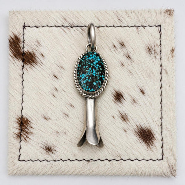 Susan Cooke Kingman spiderweb turquoise blossom pendant, front view on cowhide