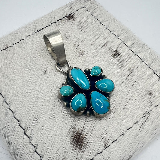 Angled view of the Sonoran turquoise cluster pendant showing hand-formed bezels and silver dot accents
