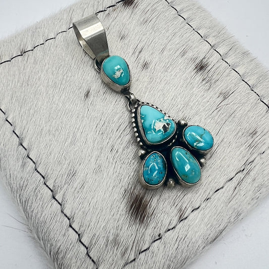 Angled view of the Blue Bird turquoise pendant showing the linked drop and silver beadwork
