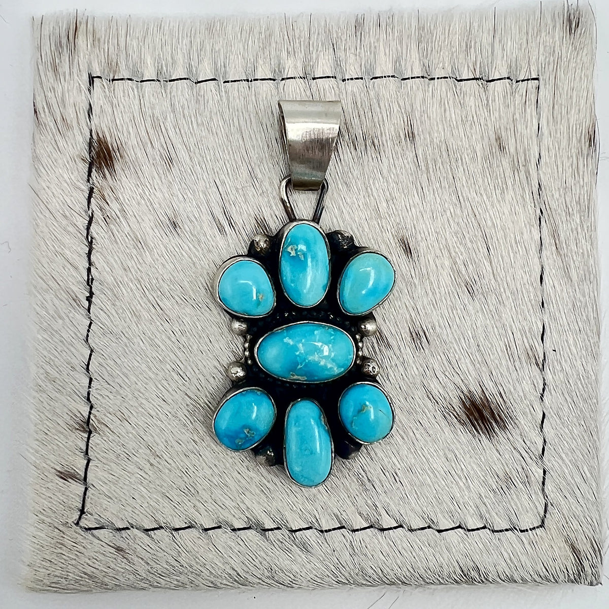 Front view of Sheila Becenti Blue Bird turquoise cluster pendant with wide silver bail