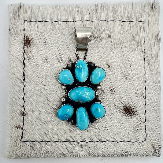 Front view of Sheila Becenti Blue Bird turquoise cluster pendant with wide silver bail