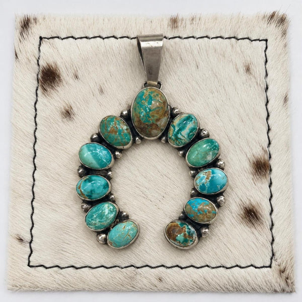 Bobby Johnson 11-stone Royston turquoise naja pendant, front view on cowhide