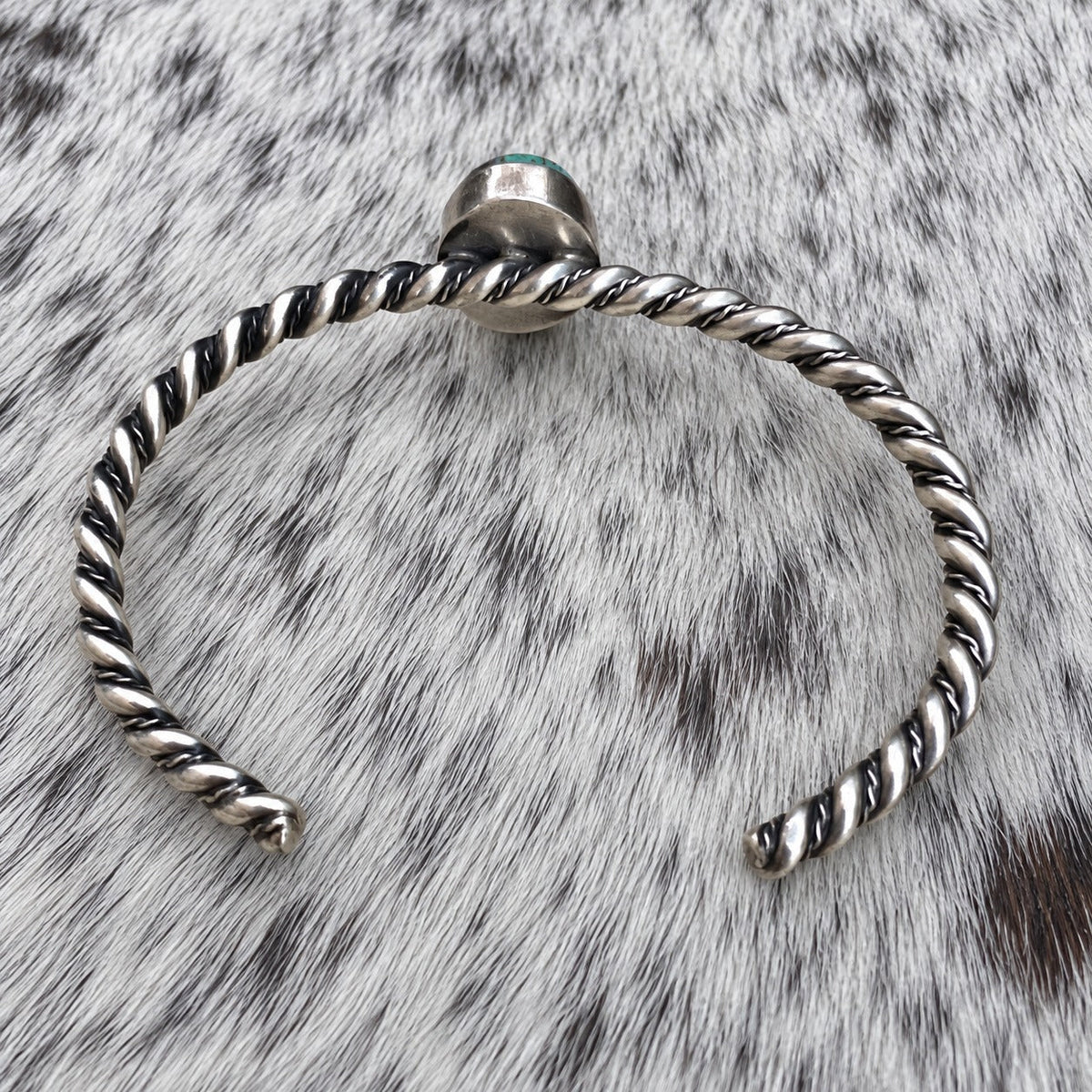 Elaine Tahe Navajo Artist Turquoise and Silver Twisted Wire Bracelet — additional catalog view on gray-and-white cowhide