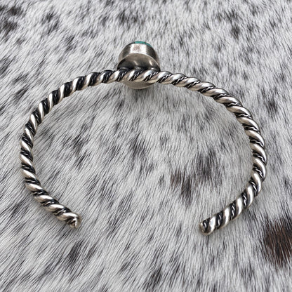 Elaine Tahe Navajo Artist Turquoise and Silver Twisted Wire Bracelet — additional catalog view on gray-and-white cowhide