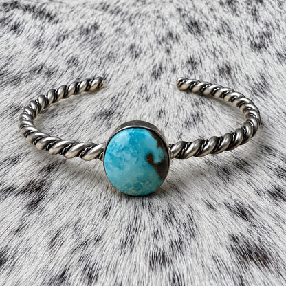 Elaine Tahe Navajo Artist Turquoise Bracelets in Sterling Silver — additional catalog view on gray-and-white cowhide