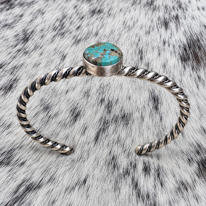Elaine Tahe Navajo Artist Turquoise and Silver Twisted Wire Bracelet — additional catalog view on gray-and-white cowhide