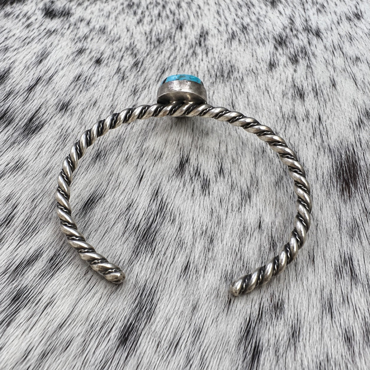Elaine Tahe Navajo Artist Turquoise Bracelets in Sterling Silver — additional catalog view on gray-and-white cowhide