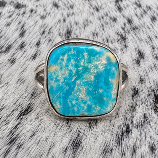 Freeform Turquoise Ring by Sheila Tso — closeup view on gray-and-white cowhide