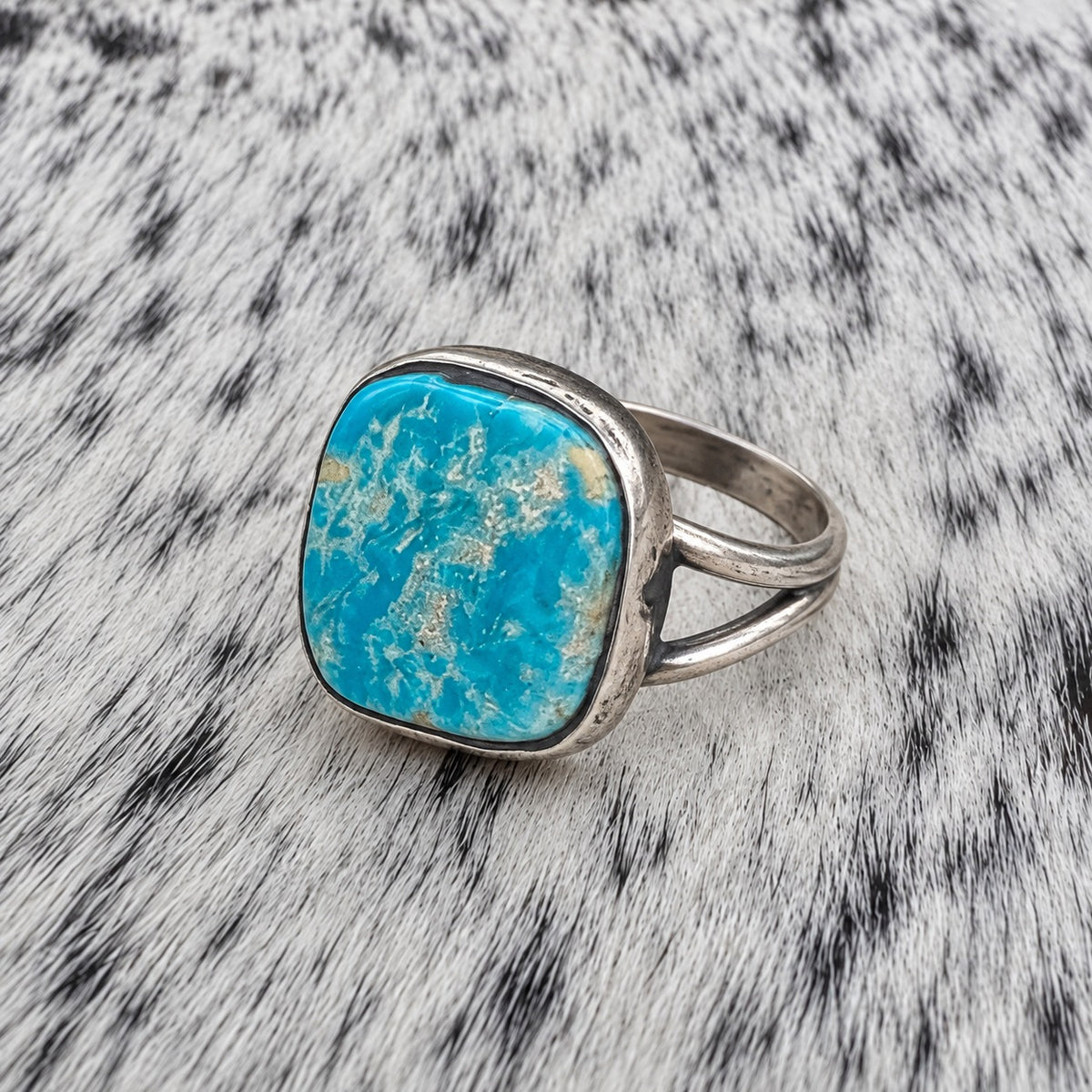 Freeform Turquoise Ring by Sheila Tso — angle view on gray-and-white cowhide