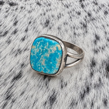 Freeform Turquoise Ring by Sheila Tso — angle view on gray-and-white cowhide