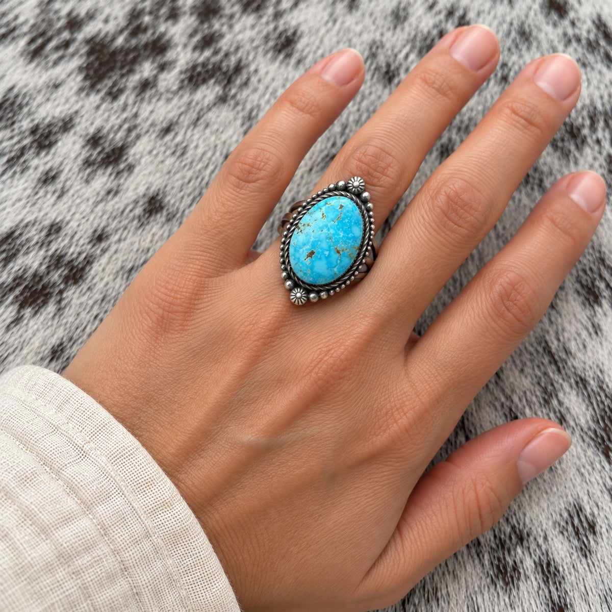 Kingman Turquoise Oval Ring by Eli Skeets worn around a finger; approximate scale