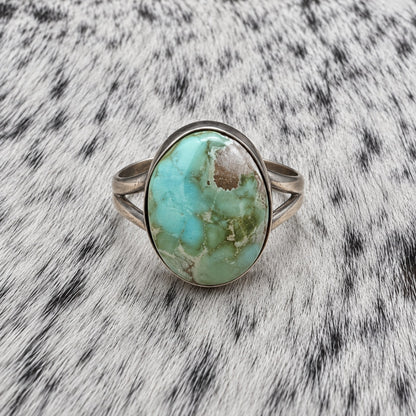 Sonoran Turquoise Ring by Susan Cooke — front view on gray-and-white cowhide