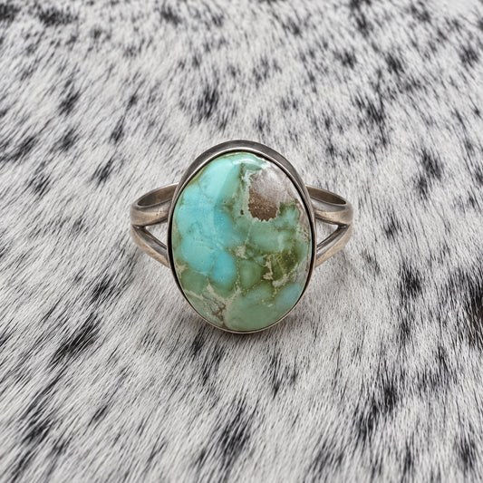 Sonoran Turquoise Ring by Susan Cooke — front view on gray-and-white cowhide