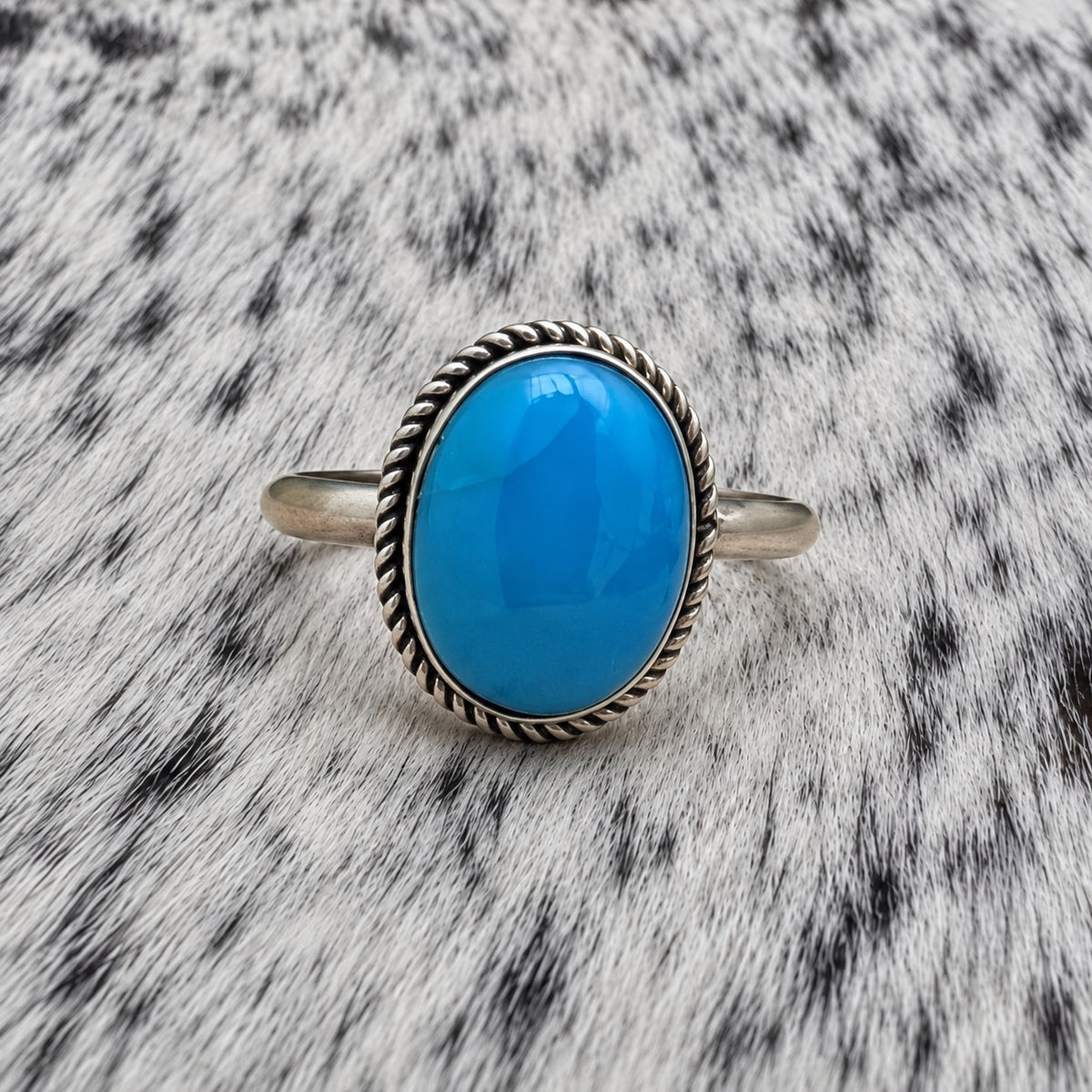 Turquoise Classic Oval Ring on gray-and-white cowhide