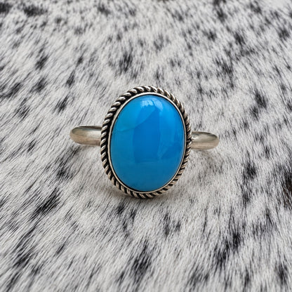 Turquoise Classic Oval Ring on gray-and-white cowhide