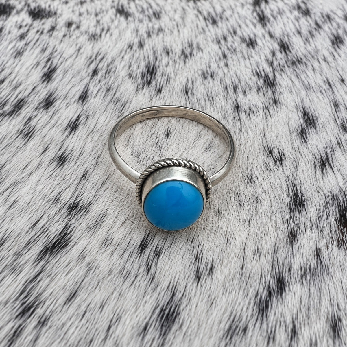 Turquoise Classic Oval Ring on gray-and-white cowhide