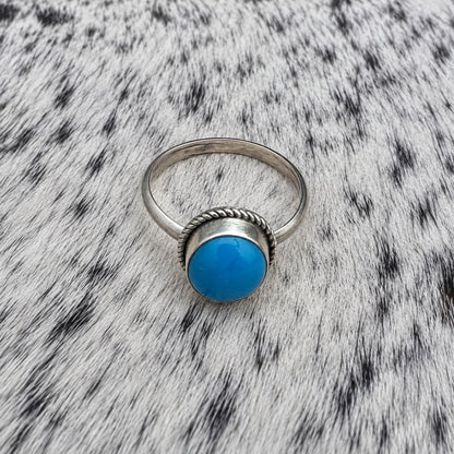 Turquoise Classic Oval Ring on gray-and-white cowhide