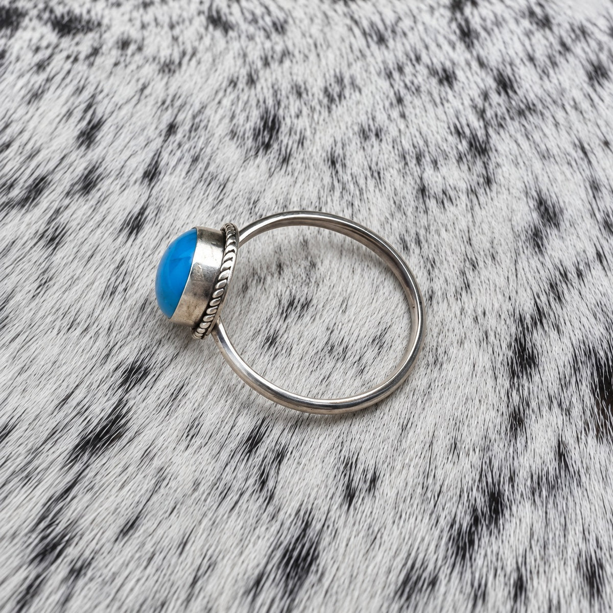 Turquoise Classic Oval Ring on gray-and-white cowhide