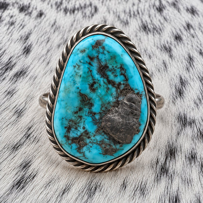 Unpolished Kingman Turquoise Ring by Susan Cooke — closeup view on gray-and-white cowhide