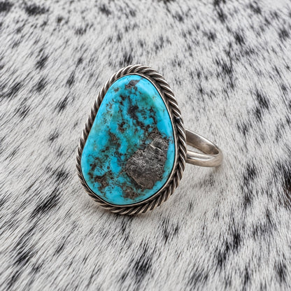 Unpolished Kingman Turquoise Ring by Susan Cooke — angle view on gray-and-white cowhide